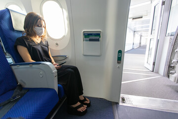 Go to トラベルでマスク姿で飛行機に乗るアジアの若い女性