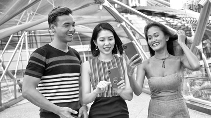 Fototapeta premium Three asian young friends enjoy outdoor time visiting a new city