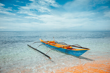 Traditionelles philippinisches Boot an einem weißen Strand im Meer