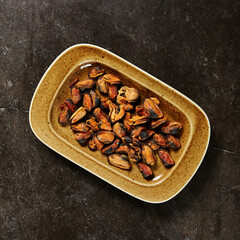 Mussels cooked without shells in tomato sauce on black marble table