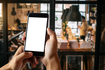 A woman hand holding smart phone device in the coffee shop or cafe background.