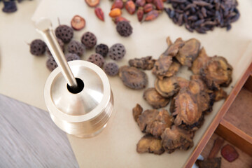 Looking down on a copper mortar and some scattered herbs on the table