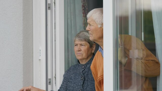 Portrait of old woman and man looking out on open window, hope and despair, ever lasting love