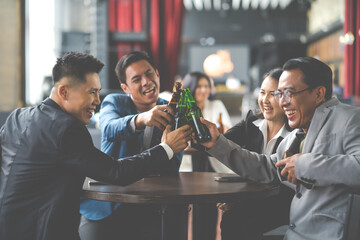 Group of friends Hands Hold Beverage Beers Bottle and toasting in the club. Celebration, Party People Christmas and Happy new year concept. Asian business people in party.