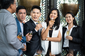 Group Of Asian Friends Enjoying Evening Drinks in bar. Celebration, Party People Christmas and Happy new year concept. Asian business people in party.