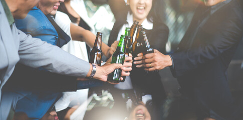 Group of friends Hands Hold Beverage Beers Bottle and toasting in the club. Celebration, Party People Christmas and Happy new year concept. Asian business people in party.