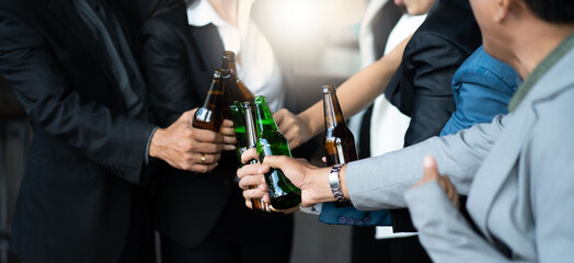 Group of friends Hands Hold Beverage Beers Bottle and toasting in the club. Celebration, Party People Christmas and Happy new year concept. Asian business people in party.