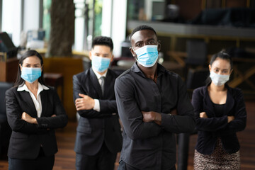 Fototapeta na wymiar Portrait Of Business Team waring face mask inside modern Office. Group of diverse business people with African American businessman leader.