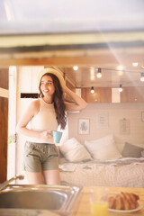 Fototapeta na wymiar Young woman with cup in trailer, space for text. Camping vacation