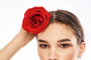 charming brunette girl with makeup on her face and a red rose in her hand