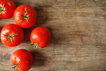 Fototapeta na wymiar Fresh ripe tomatoes on wooden table, flat lay. Space for text