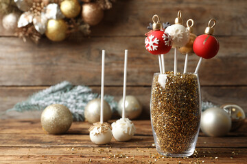 Composition with delicious Christmas ball cake pops on wooden table