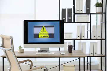 Computer with warning about virus attack on screen in office