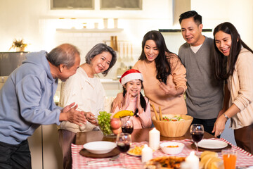 Asian big family sing a song while preparing foods for Christmas party