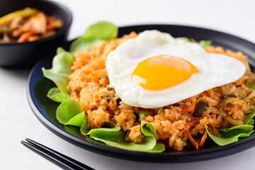 Korean food, Kimchi fried rice with fried egg on top and fresh kimchi cabbage