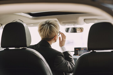 Businesswomanin a car. Lady in a black suit.