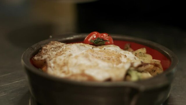 A plate with fried egg and austrian gr&ouml;stl with fresh tomatos. Racking Focus. Shot in 4K.