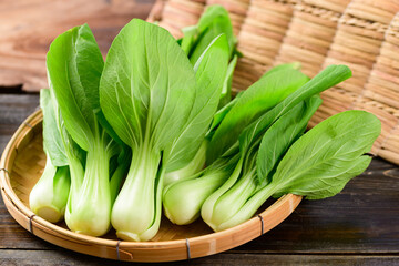 Fresh Bok Choy or Pak Choi (Chinese cabbage) in bamboo basket on wooden background, Organic vegetables