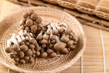 Fresh brown Shimeji mushroom in a woven bamboo basket, Asian mushroom