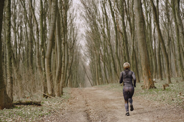 Obraz premium Woman in mask. Girl in a park. Coronavirus theme. Woman training.
