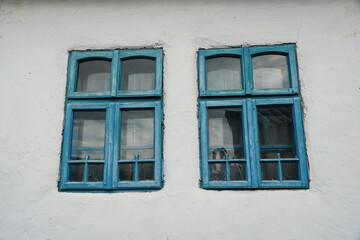 old blue windows to a house painted white