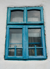 old blue windows to a house painted white