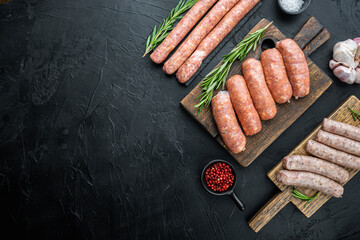 Assorted raw homemade sausages, flat lay with space for text, on black background