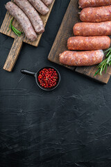 Assorted raw homemade sausages, flat lay with space for text, on black background