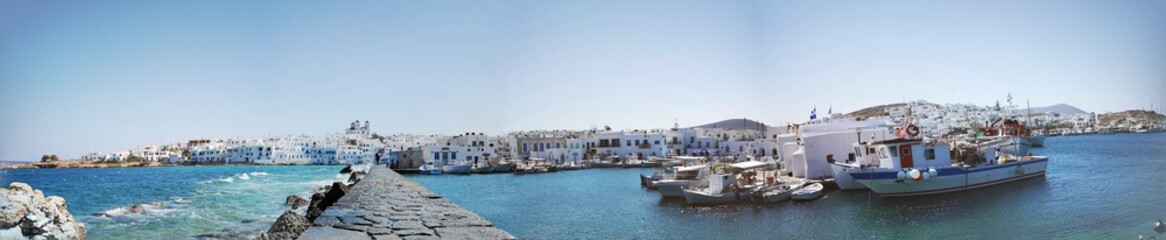 Fototapeta na wymiar beautiful panorama of the village of Naousa with coast and traditional historical white Greek buildings on the island of Paros, Greece