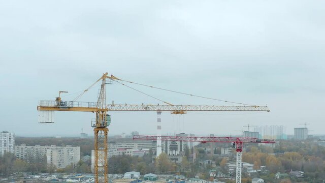 High crane works on building site. Aerial drone view of construction site crane over city