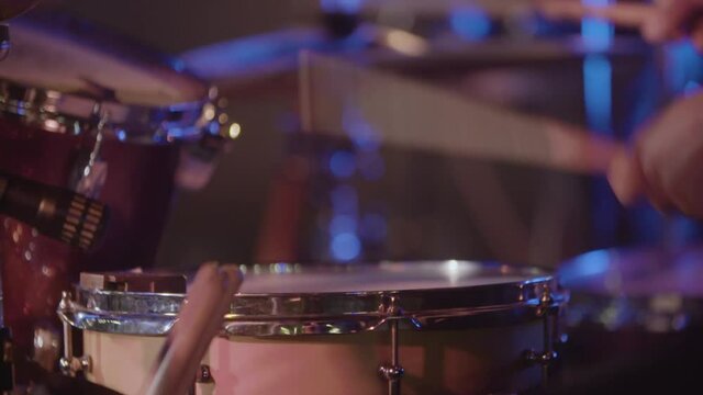 Slow motion close up of a drum player's hands during concert
