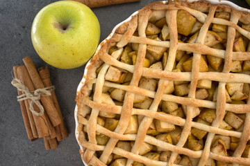 Classic apple pie with lattice decoration. Gray background with copy space. Homemade dessert tart...