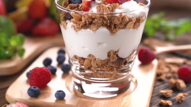 Scooping Yogurt with granola and fruits