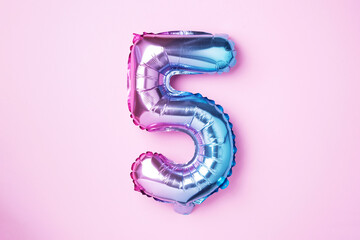 Creative layout. Rainbow foil balloon number and digit five 5. Birthday greeting card. Anniversary concept. Top view. Copy space. Stylish colored numeral over pink background. Numerical digit. - obrazy, fototapety, plakaty