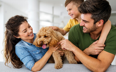 Happy family playing, having fun with dog at home