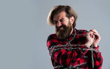 Get rid of the problems. mature hipster break chain. fetter. brutal man with chain. chained up in chains. bearded man has aggressive look. express his strength. male power and masculinity. copy space