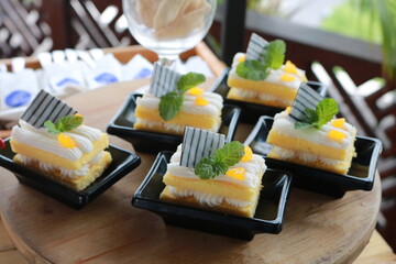 Slice of delicious vanilla cake on wooden table.