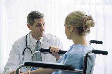 Obraz premium Doctor talking and consultant to patient in wheelchair at hospital.