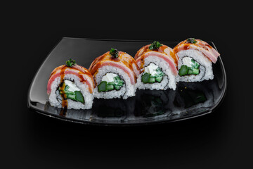 freshly made Japanese sushi rolls served on a black stone slab