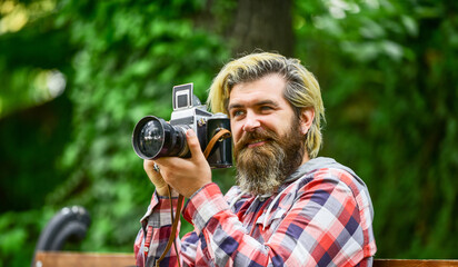 professional photographer use vintage camera. bearded man hipster take photo. photo shooting...