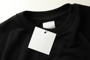 Stylish blank black sweatshirt on white table