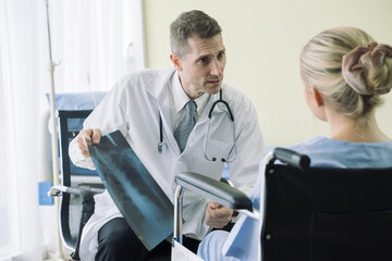 Doctor show and discussing with patient about x-ray film and medical treatments in examination room at hospital,Medical healthcare job, or hospital business concept.