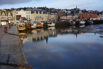 Fototapeta na wymiar mirror reflection of boats in the harbour and the town of Trouville, France