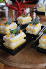 Slice of delicious vanilla cake on wooden table.