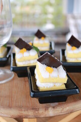 Slice of delicious vanilla cake on wooden table.