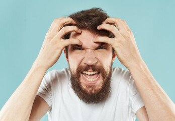 irritable man with beard on blue background portrait cropped view
