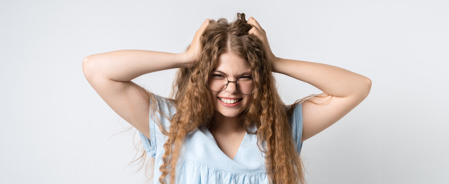 Photo of beautiful emotional girl holding hands on head. Problems, surprise, fear, fobia concept