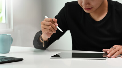Cropped shot of graphic designer or photographer hand holding stylus pen drawing on the graphic...