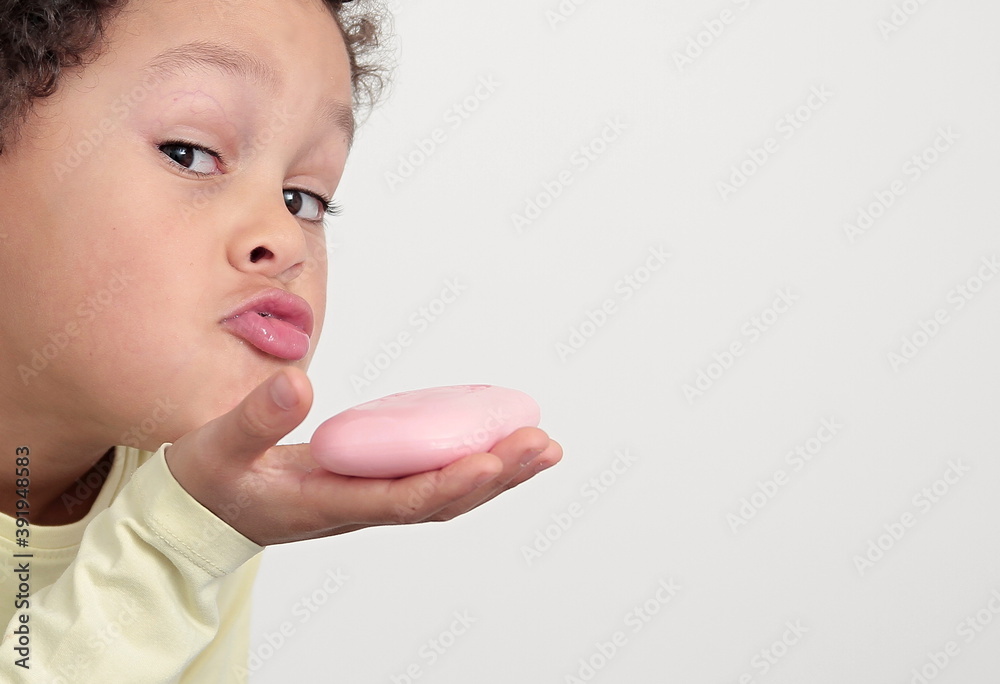 Wall mural little boy with bar of soap washing hands keeping safe from coronavirus stock photo