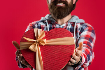 birthday surprise for her. anniversary of marriage. happy valentines day. heart is symbol of love. bearded man casual style hold gift box. time for presents. love holiday and vacation. Be happy